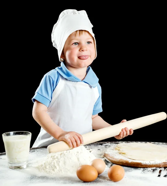 Kleiner Junge bei der Herstellung von Pizza oder Nudelteig. isoliert auf schwarz — Stockfoto