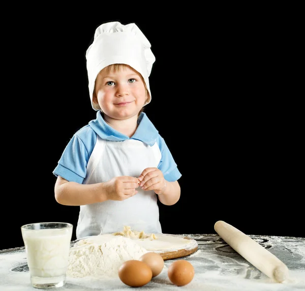 Μικρό αγόρι κάνοντας πίτσα ή ζυμαρικά ζύμη. Απομονώνονται σε μαύρο. — Φωτογραφία Αρχείου