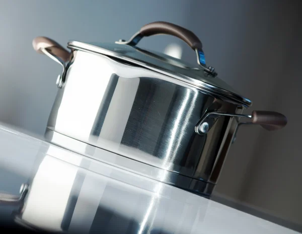 Metal pot with glass lid. Selective focus.Little of DOFF