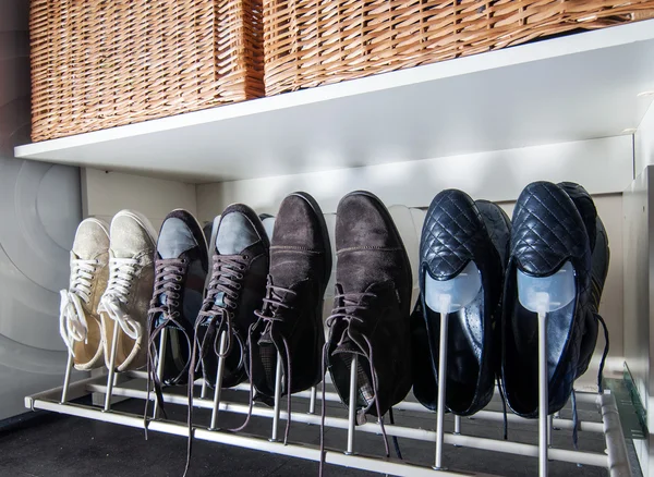 Some pairs of men's shoes on SHOE RACK in the storeroom at home