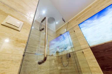 Parlak ve beyaz banyo beyaz küvet ile bej döşeme zemin, cam kapı duş