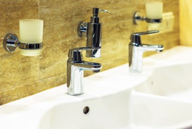 Lüks banyo küveti ve su dolu musluk.