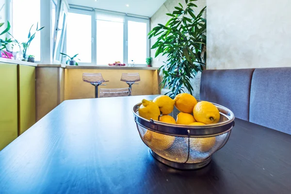 Interior de la pequeña cocina blanca con limones amarillos en la mesa —  Fotos de Stock