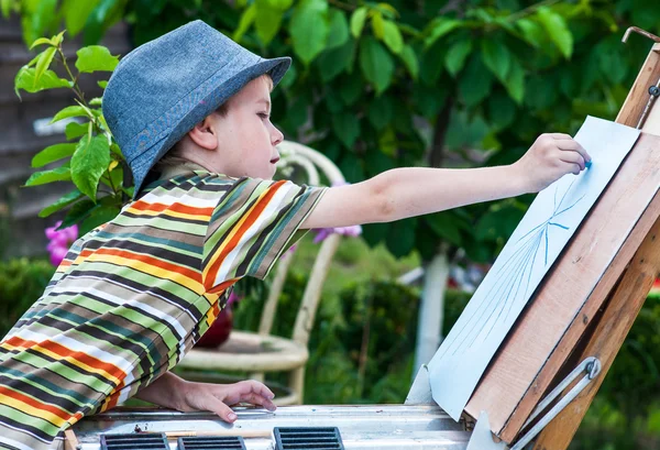 Kleiner Junge zeichnet ein Bild im Freien — Stockfoto