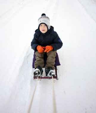 Sevimli genç çocuk kızakları üzerinde.