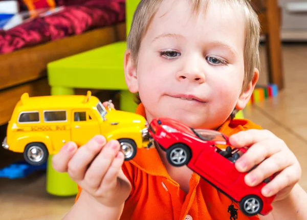 little boy plays with toy car