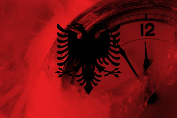 Albania, Albanian flag with clock close to midnight in the background. Happy New Year concept