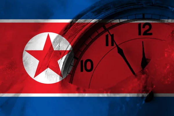North Korea, Korean flag with clock close to midnight in the background. Happy New Year concept