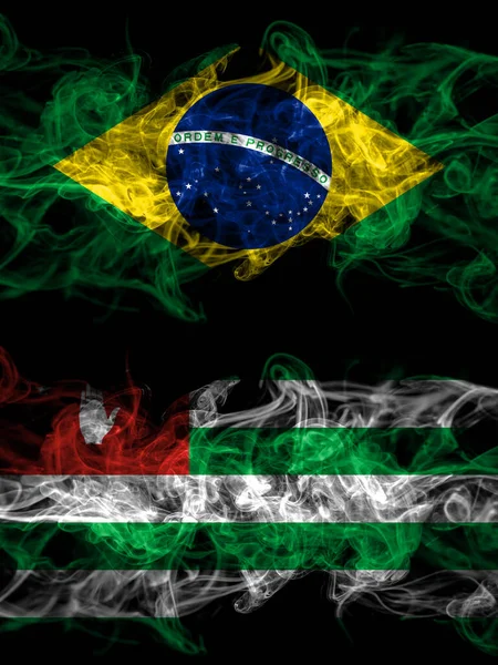 ブラジル ブラジル対アブハジア アブハジアのスモーキーな神秘的な旗が並んで配置されます 濃い色の絹のような抽象的な煙のフラグ — ストック写真