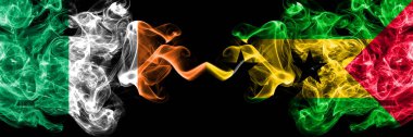 Republic of Ireland, Irish vs Sao Tome and Principe smoky mystic flags placed side by side. Thick colored silky abstract smoke flags.