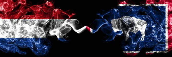 荷兰对美国 怀俄明州的烟熏神秘旗肩并肩放置 浓密的彩色丝状抽象烟旗 — 图库照片