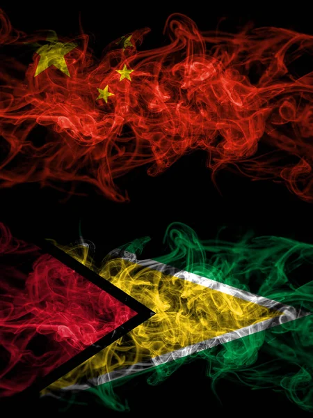 China, Chinese vs Guyana smoky mystic flags placed side by side. Thick colored silky abstract smoke flags.