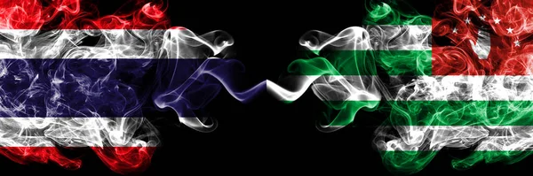 Thailand, Thai vs Abkhazia, Abkhzian smoky mystic flags placed side by side. Thick colored silky abstract smokes flags.