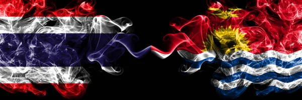 Thailand, Thai vs Kiribati smoky mystic flags placed side by side. Thick colored silky abstract smokes flags.