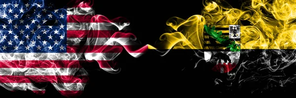 United States of America, America, US, USA, American vs Saxony Anhalt, state smoky mystic flags placed side by side. Thick colored silky abstract smoke flags.