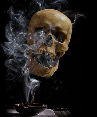bir insan kafatası arka plan üzerinde puro içiyor