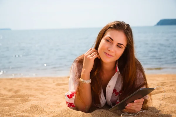 Gyönyörű lány használ egy tabletta Pc a strandon — Stock Fotó