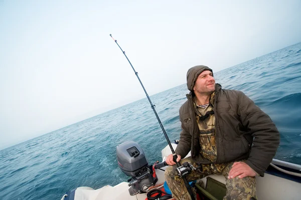 Fiskare fångar en lax i havet — Stockfoto