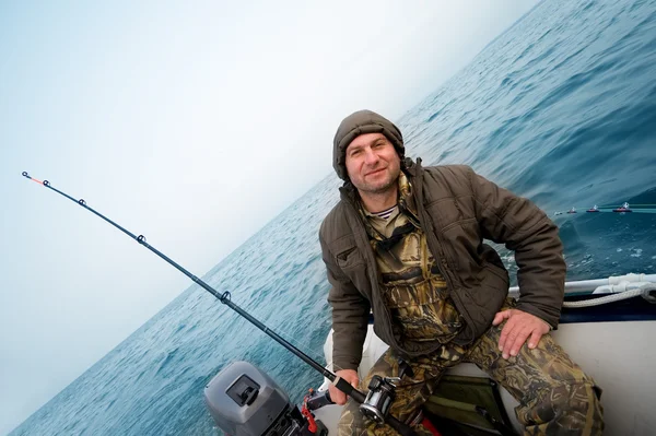 Pescador captura un salmón en el mar — Foto de Stock