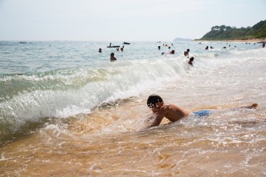 Çocuk sörf yüzüyor