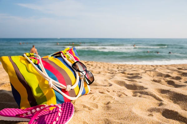 Женские пляжные аксессуары на песчаном берегу — стоковое фото
