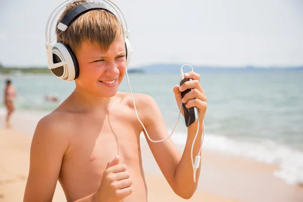 Lächelnder Junge mit Kopfhörer und Smartphone — Stockfoto