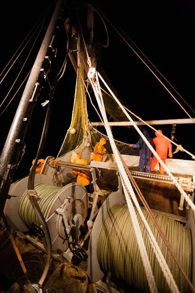 Fishermen standing at the stern of small fishing vessel — Stock Photo, Image