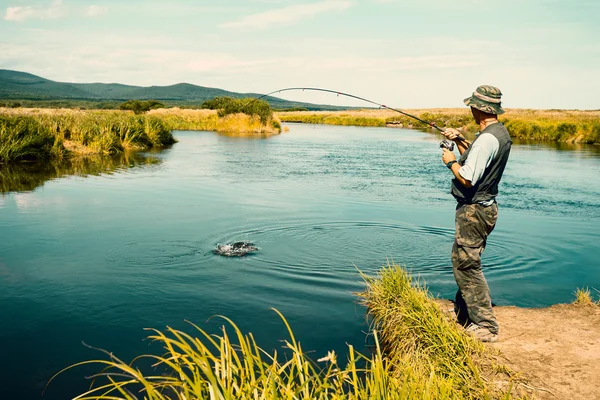 Mellersta åldern man fiskar fångas laxrosa från floden — Stockfoto