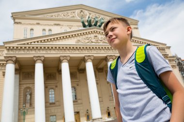 Boy stands in background of the Bolshoi Theatre clipart
