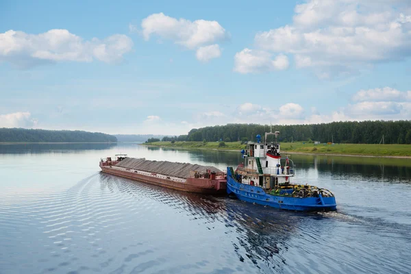 Bogserbåten flyttar pråm på floden Volga — Stockfoto