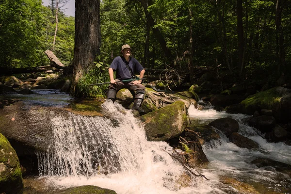 Fisherman has a rest sitting by the river — Stock Photo, Image