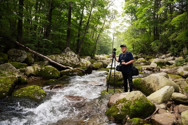 Viajante fotógrafo em um rio de montanha — Fotografia de Stock