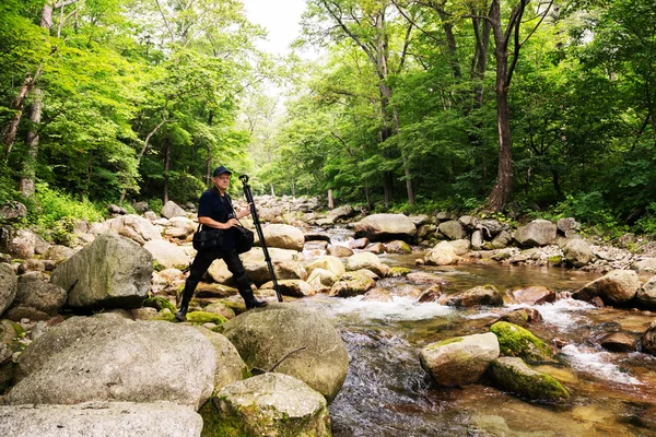 Photographer traveler on a mountain river — Stock Photo, Image