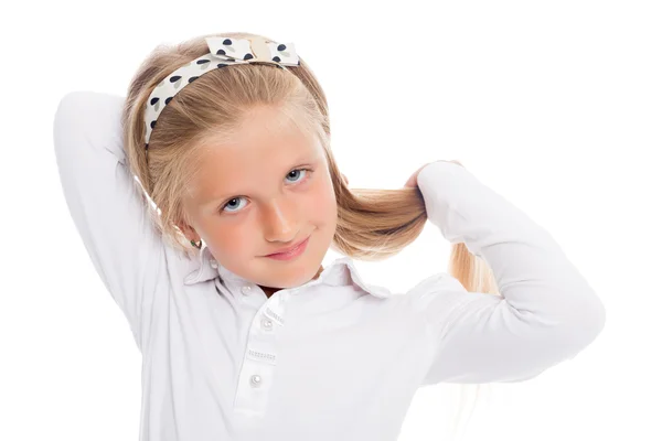 Pequena menina loira coloca seu cabelo longo . — Fotografia de Stock