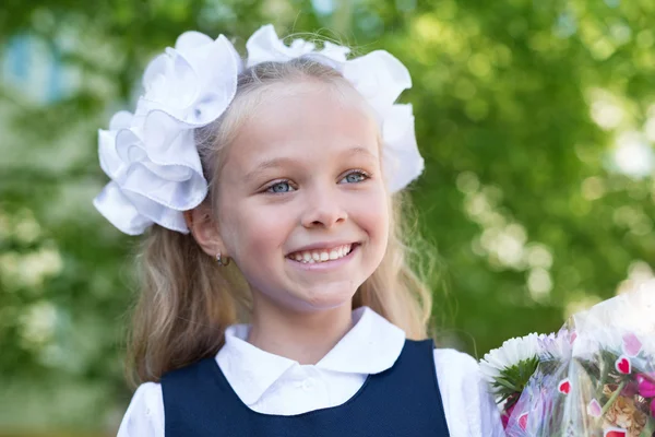 Ragazza gioiosa primo alunno con fiori — Foto Stock