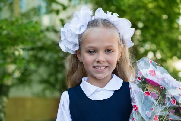 First grader girl with flowers — Stock Photo, Image