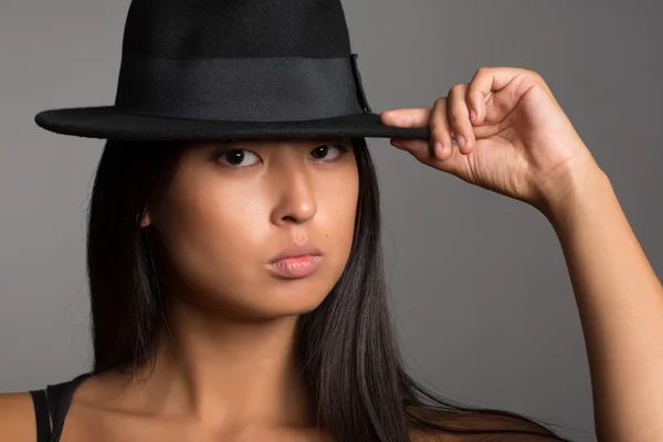 Young pretty asian girl in a black hat — Stock Photo, Image