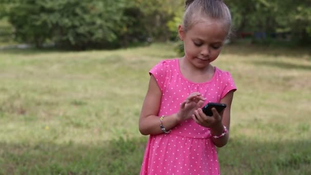 Adorable petite fille de six ans à parler sur un téléphone portable — Video