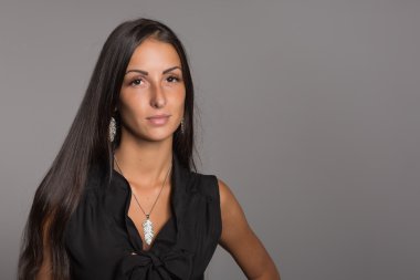 Gri arka planda genç bir kadın