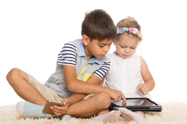 Bror och syster spelar för tablet pc — Stockfoto