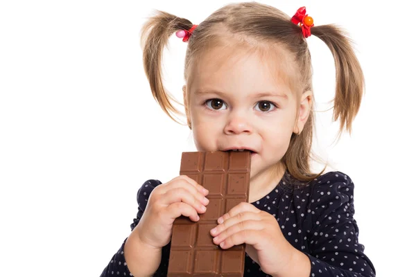 Маленькая девочка ест шоколад — стоковое фото