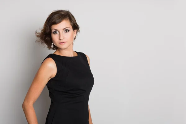 Mujer en una pared gris — Foto de Stock