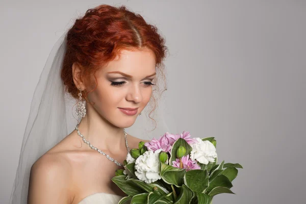 Affascinante sposa guarda un bouquet — Foto Stock