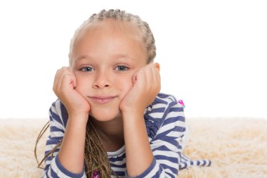 Sevimli küçük kız halının üzerinde yalan