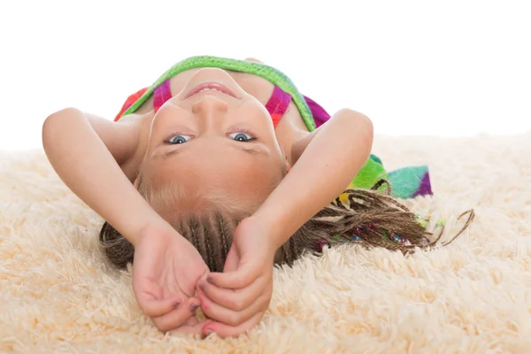Happy little girl lays on her back — Stock Photo, Image