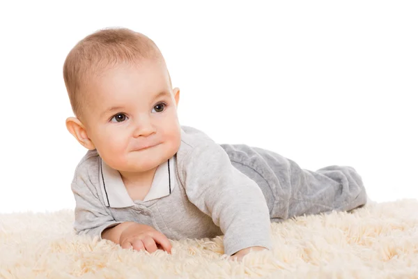 Schattige kleine jongen liggen op het tapijt — Stockfoto