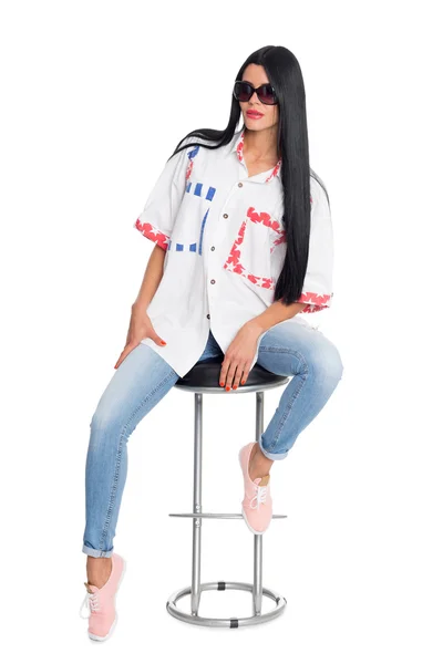 Junge schlanke elegante Frau sitzt auf einem Stuhl — Stockfoto