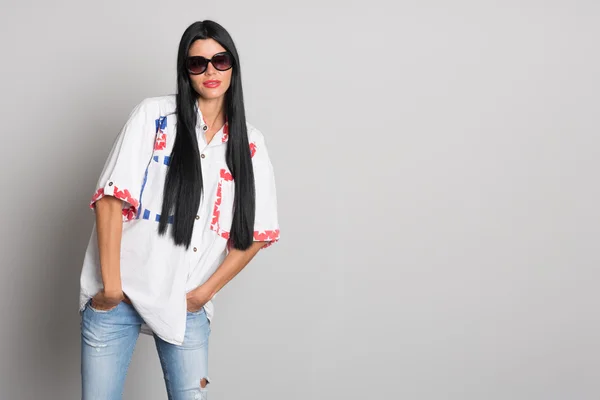 Mujer joven con estilo posando de pared gris — Foto de Stock