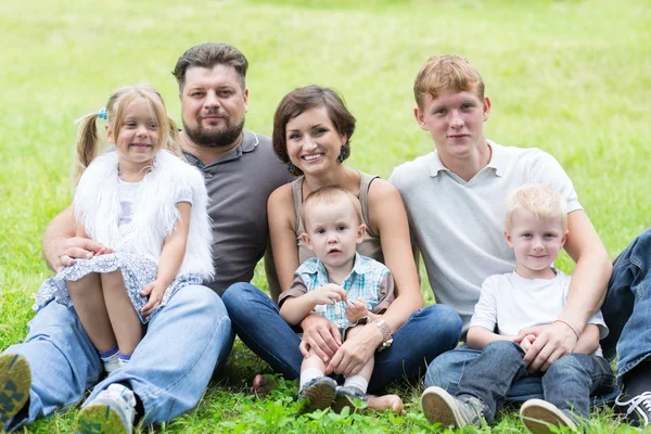 Heureuse famille reposant sur l'herbe — Photo