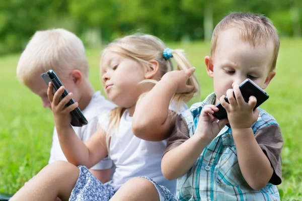 De gelukkige kinderen met behulp van smartphones — Stockfoto